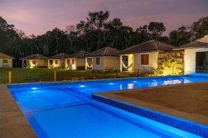 a swimming pool in front of a house at night at Montanhas Do Visconde in Visconde De Maua