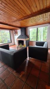 sala de estar con 2 sofás y chimenea en Hostal San Rafael La Calera, en La Calera