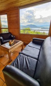 a living room with a couch and a table and windows at Hostal San Rafael La Calera in La Calera