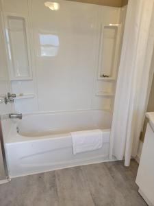 a white bath tub with a shower curtain in a bathroom at Gateway Motel in Gananoque