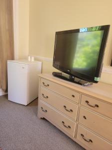 a flat screen tv sitting on top of a dresser at Gateway Motel in Gananoque
