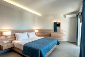 a bedroom with a large bed with a blue blanket at Orama apartment in Nea Kydonia