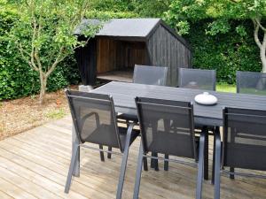 una mesa de comedor negra y sillas con una caseta para perros en 6 person holiday home in Struer en Remmer Strand