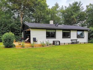 une petite maison blanche avec une cour d'herbe dans l'établissement 5 person holiday home in Vinderup, à Vinderup