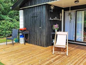 a wooden deck with a shed and a chair at 5 person holiday home in Vinderup in Vinderup