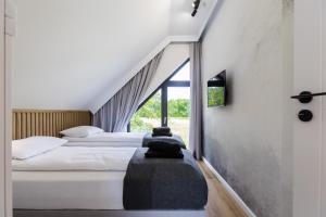 dwa łóżka w pokoju z oknem w obiekcie Mare Boutique Houses w mieście Niechorze
