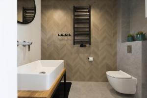 łazienka z białą umywalką i toaletą w obiekcie Mare Boutique Houses w mieście Niechorze