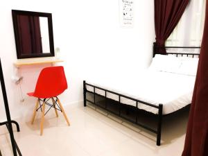 ein Schlafzimmer mit einem schwarzen Etagenbett und einem roten Stuhl in der Unterkunft The Loft Imago, Block D - BeOurGuest- in Kota Kinabalu