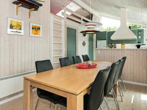 ein Esszimmer mit einem Holztisch und Stühlen in der Unterkunft 8 person holiday home in Ebeltoft in Ebeltoft