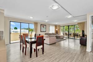 a living room filled with furniture and a large window at Eden by the Bay in Hervey Bay
