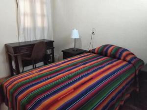 Calvary house في أنتيغوا غواتيمالا: غرفة نوم بسرير مع مكتب وكرسي