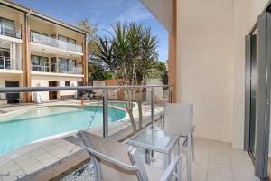 a patio with a pool and chairs and a pool table at Eden by the Bay in Hervey Bay