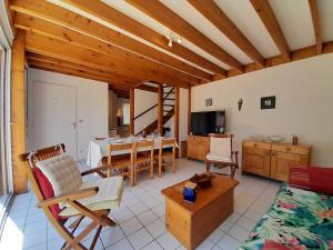 a living room with a table and chairs and a television at Villa Carnac, 3 pièces, 6 personnes - FR-1-477-207 in Carnac