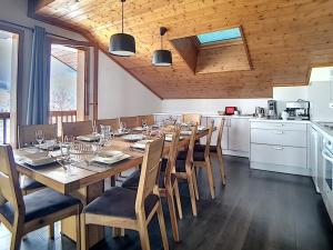 a dining room with a large wooden table and chairs at Appartement Les Menuires, 6 pièces, 12 personnes - FR-1-344-775 in Levassaix