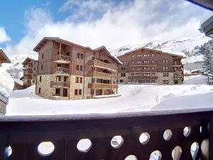 a large building in the snow with mountains in the background at Appartement spacieux près des pistes avec balcon, sauna, hammam et WIFI - FR-1-344-775 in Levassaix