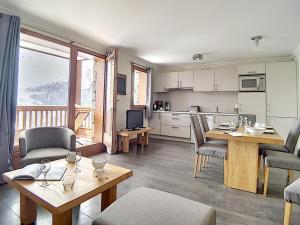a kitchen and living room with a table and chairs at Appartement rénové proche pistes avec Sauna, Hammam et WIFI - FR-1-344-788 in Levassaix