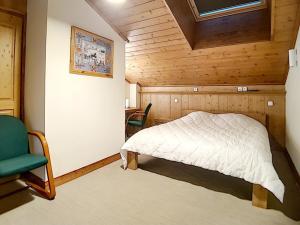 a bedroom with a bed and a green chair at Appartement spacieux et rénové, 10 personnes, 4 Flocons OR, sauna et hammam - FR-1-344-786 in Levassaix