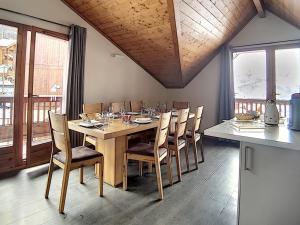 a dining room with a wooden table and chairs at Appartement spacieux et rénové, 10 personnes, 4 Flocons OR, sauna et hammam - FR-1-344-786 in Levassaix +8 photos