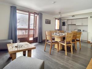 a kitchen and dining room with a table and chairs at Appartement Les Menuires, 4 pièces, 8 personnes - FR-1-344-799 in Levassaix