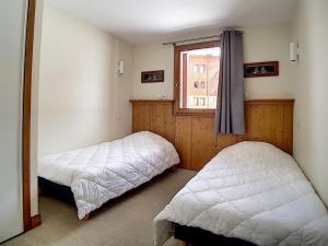 a bedroom with two beds and a window at Appartement Les Menuires, 4 pièces, 8 personnes - FR-1-344-799 in Levassaix