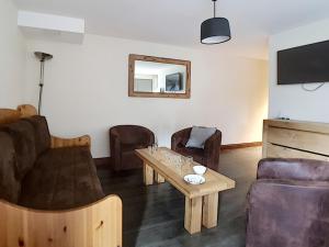 a living room with a couch and a table at Appartement de standing rénové aux Belleville avec balcon, accès pistes, WiFi, sauna et hammam - FR-1-344-808 in Levassaix