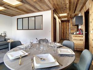 a dining room with a table with wine glasses on it at Appartement Les Menuires, 2 pièces, 6 personnes - FR-1-344-831 in Levassaix