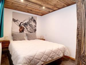a bedroom with a bed with a picture on the wall at Appartement rénové 6 pers. proche pistes avec balcon, hammam, sauna - FR-1-344-831 in Levassaix