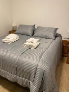 Una cama con dos toallas encima en Departamento Andes Drury - Deptosxlosandes, en San Martín de los Andes