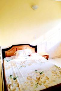 a bedroom with a bed with flowers on it at 8 bedroom holiday home with great ambiance in Ofatedo