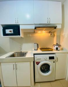 een keuken met een wasmachine en een wastafel bij 8 Spatial Condominium in Davao City
