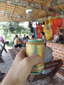 a person holding a can of soda in their hand at Pink Buffalo Eco-Resort in Ban Na Nga