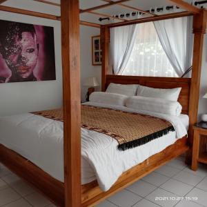 a bedroom with two beds and a large window at Soul Lodge Villa Lovina in Banjar