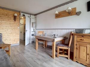 een keuken met een houten tafel en houten stoelen bij Studio Les Menuires, 1 pièce, 2 personnes - FR-1-344-888 in Les Menuires