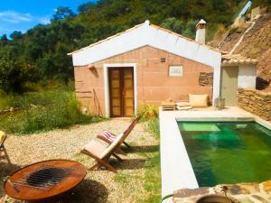 een klein huis met een zwembad naast een gebouw bij Casas da Cerca in Troviscais