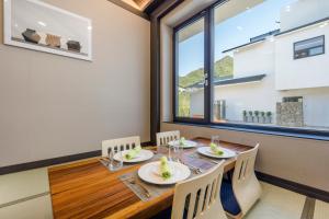 a dining room with a table and chairs and a large window at Hotel HaruSida in Seogwipo