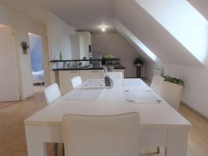- une cuisine avec une table blanche et des chaises blanches dans l'établissement Appartement La Forêt-Fouesnant, 3 pièces, 4 personnes - FR-1-481-121, à La Forêt-Fouesnant