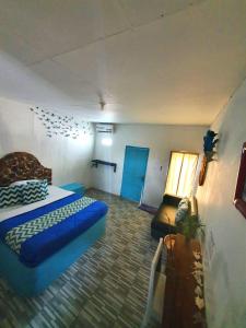 Cette chambre comprend un lit, un canapé et une table. dans l'établissement Blue Coral Homestay, à Karimunjawa