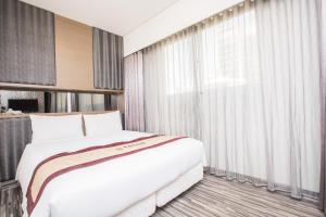 Postel nebo postele na pokoji v ubytování Harmonious Hotel