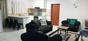 a living room with two chairs and a kitchen at LILIAN Self Catering Accommodation in Swakopmund