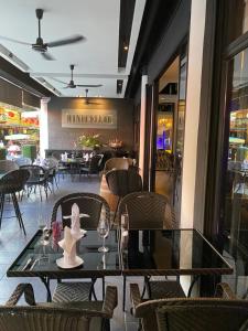 a dining room with tables and chairs in a restaurant at Poseidon Boutique Hotel in Pattaya South