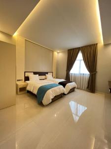 a bedroom with a large bed and a window at Aalia Hotel Suites in Sohar