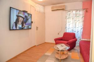 a living room with a red chair and a flat screen tv at Central sea view apartment in Komiža