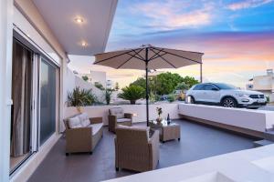 a patio with an umbrella and a car on a balcony at Vakakis Family Luxury Studios in Palaiochora