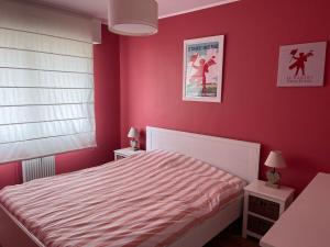 sypialnia z czerwonymi ścianami i białym łóżkiem w obiekcie Le Touquet - Superbe appartement 3 chambres - Proche mer & centre - Wifi w mieście Le Touquet-Paris-Plage