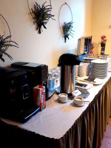 uma mesa com uma máquina de café em cima em Hotel Santa em Sigulda