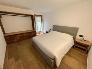 a bedroom with a white bed and a window at Casa Fabiolin in Daiano