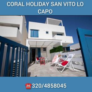 una ricostruzione di una casa con sedie e patio di Coral Holiday San Vito Lo Capo a San Vito lo Capo