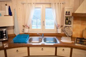 een keuken met een wastafel en een raam bij Nel verde del Villaggio - Casetta Celeste in Gonnesa