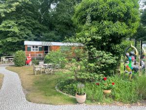 un jardín con una casa en el fondo con un edificio en Zirkuswagen am Landhaus Labes (Stechlinsee) en Neuglobsow