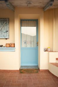 uma porta azul da frente de uma casa em Nel verde del Villaggio - Casetta Celeste em Gonnesa